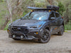 A Subaru Crosstrek fitted with a black rally light bar on top for enhancing visibility, positioned against an outdoor backdrop.