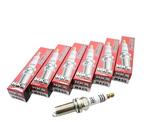 A set of six HKS SUPER FIRE RACING M45iL spark plugs, with each plug in a red and silver box.