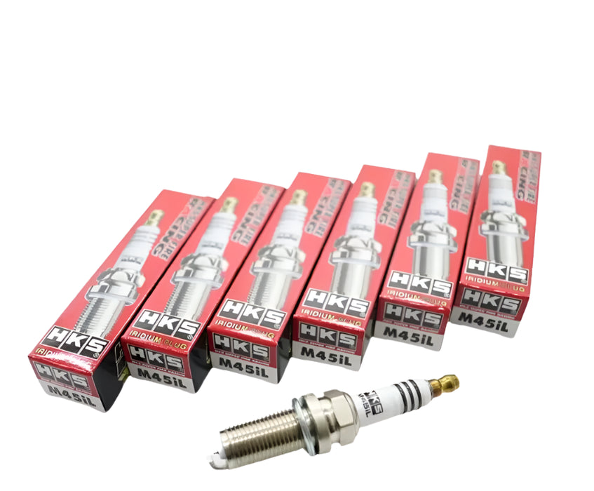 A set of six HKS SUPER FIRE RACING M45iL spark plugs, with each plug in a red and silver box.