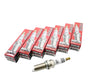A set of six HKS SUPER FIRE RACING M45iL spark plugs, with each plug in a red and silver box.